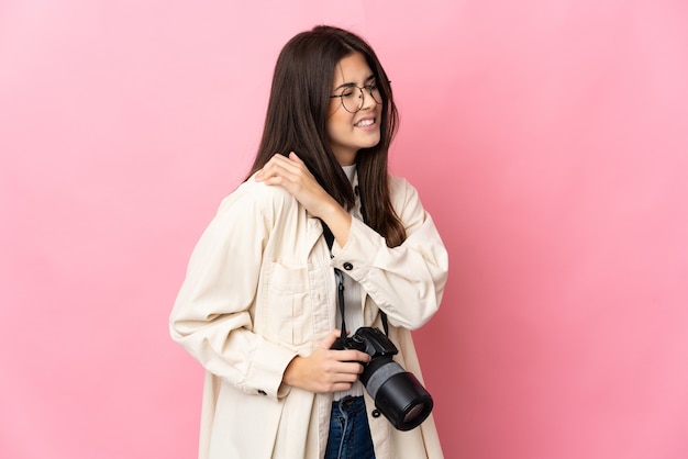 Giovane fotografo brasiliano ragazza isolata in rosa soffre di dolore alla spalla per aver fatto uno sforzo