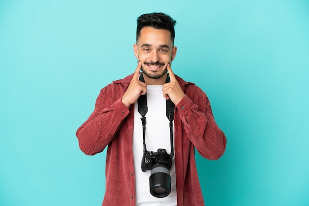 Giovane fotografo caucasico uomo isolato su sfondo blu sorridente con un'espressione felice e piacevole