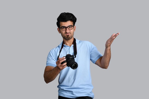 giovane fotografo che tiene la macchina fotografica e indica il modello pakistano indiano