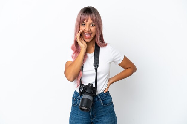 Giovane fotografo di razza mista donna con capelli rosa isolato su sfondo bianco che grida con la bocca spalancata