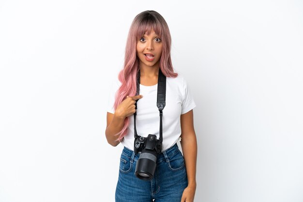 Giovane fotografo di razza mista donna con capelli rosa isolato su sfondo bianco con espressione facciale a sorpresa