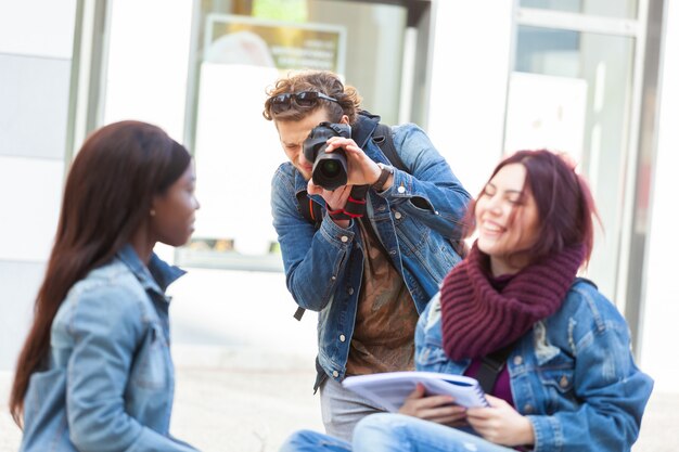 Giovane fotografo di scattare fotografie di due ragazze mentre studiava.