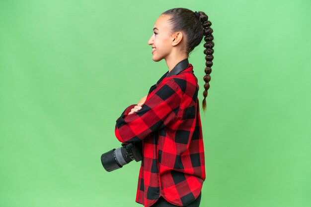 Giovane fotografo donna araba su sfondo isolato in posizione laterale