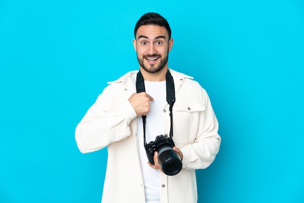 Giovane fotografo uomo isolato con espressione facciale sorpresa