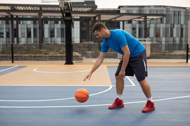 Giovane giocatore di basket che gioca a basket nel campo da basket