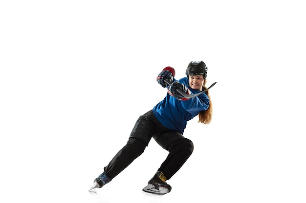 Giovane giocatore di hockey femminile con il bastone sul campo di ghiaccio e sfondo bianco. Sportiva che indossa l'attrezzatura e l'allenamento del casco. Concetto di sport, stile di vita sano, movimento, azione, emozioni umane.