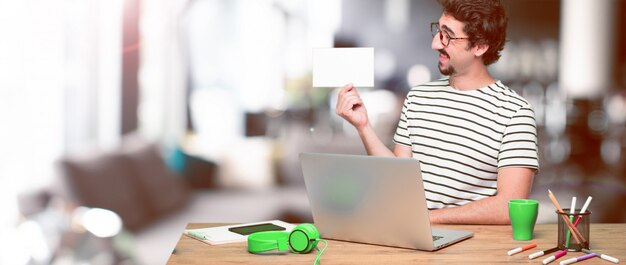 Giovane grafico pazzo su una scrivania con un computer portatile