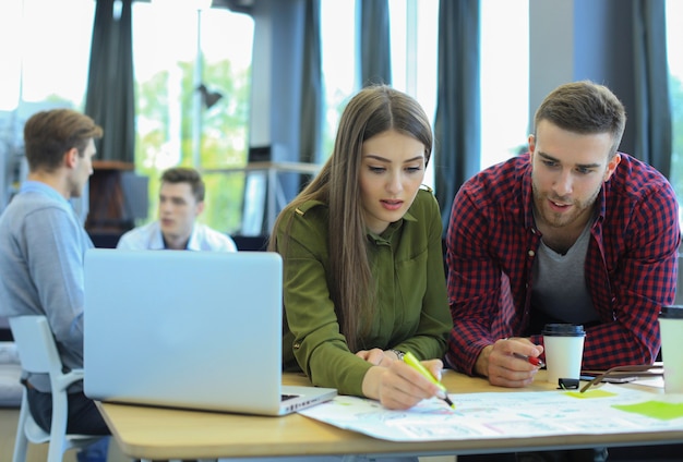 Giovane gruppo di persone che fanno il loro lavoro sul computer portatile.