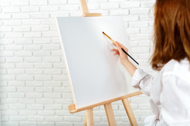 Giovane immagine femminile della pittura dell'artista in studio