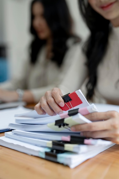 Giovane impiegato di Office che lavora con documenti e computer portatile al tavolo