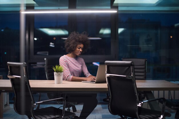 Giovane imprenditore afroamericano libero professionista che lavora utilizzando un computer portatile nello spazio di coworking