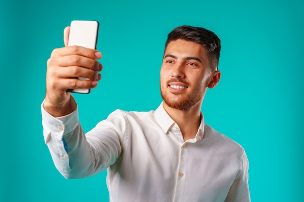 Giovane imprenditore in camicia bianca tenendo selfie