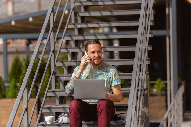 Giovane, imprenditore in cerca di lavoro utilizzando laptop all'aperto,