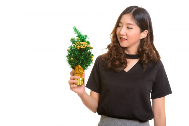 Giovane imprenditrice asiatica felice azienda albero di felice anno nuovo isolato contro bianco