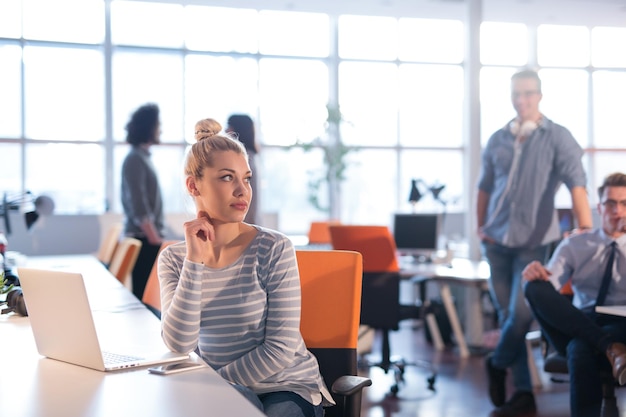 Giovane imprenditrice freelance femminile che lavora utilizzando un computer portatile nello spazio di coworking