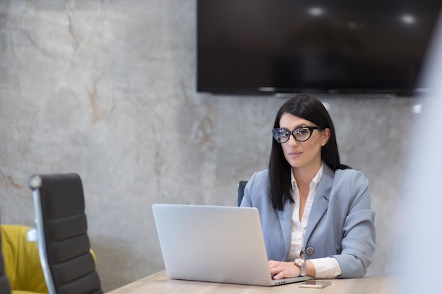 Giovane imprenditrice freelance femminile che lavora utilizzando un computer portatile nello spazio di coworking