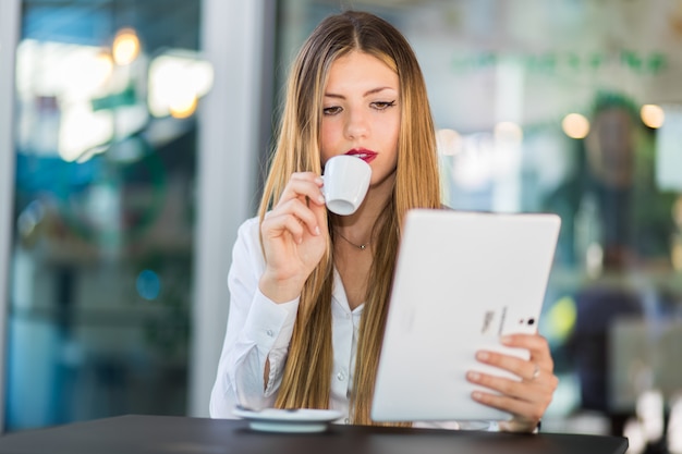 Giovane imprenditrice in pausa caffè. Utilizzo del tablet PC.