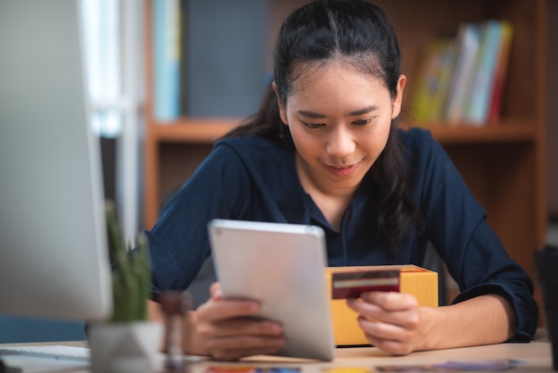 Giovane imprenditrice lavorando shopping online a casa sua