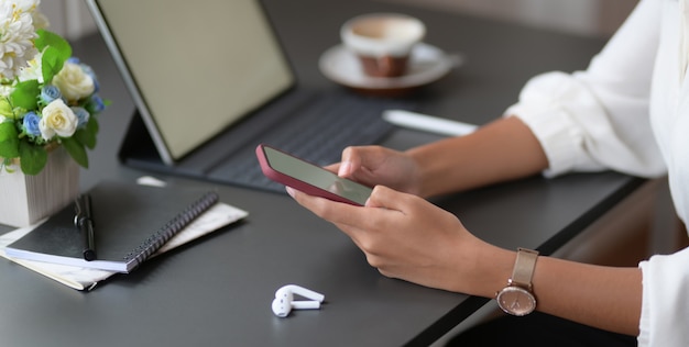 giovane imprenditrice lavorando sul suo progetto durante l'utilizzo di smartphone