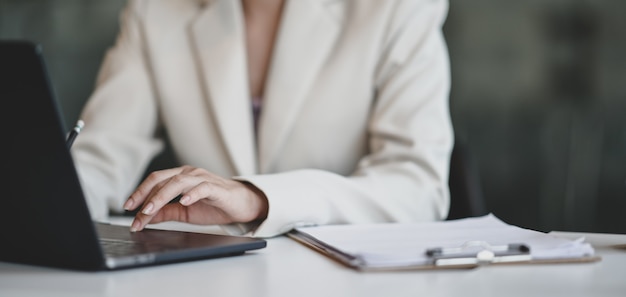 giovane imprenditrice professionale lavorando sul suo progetto durante la digitazione sul computer portatile