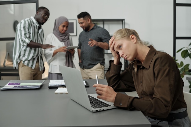 Giovane imprenditrice stanca che cerca di concentrarsi durante il lavoro sul progetto