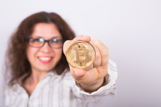 Giovane imprenditrice tenendo un bitcoin dorato