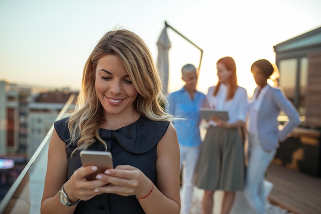 Giovane imprenditrice utilizzando il telefono per importanti chiamate d'affari.