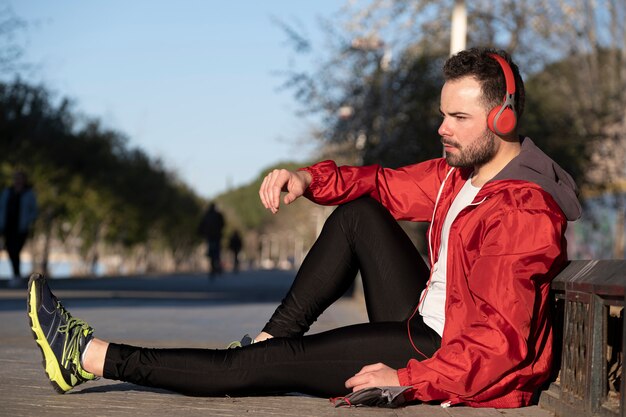 Giovane in abiti sportivi che ascolta la musica con un paio di cuffie