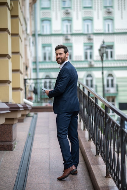 Giovane in abito elegante al balcone