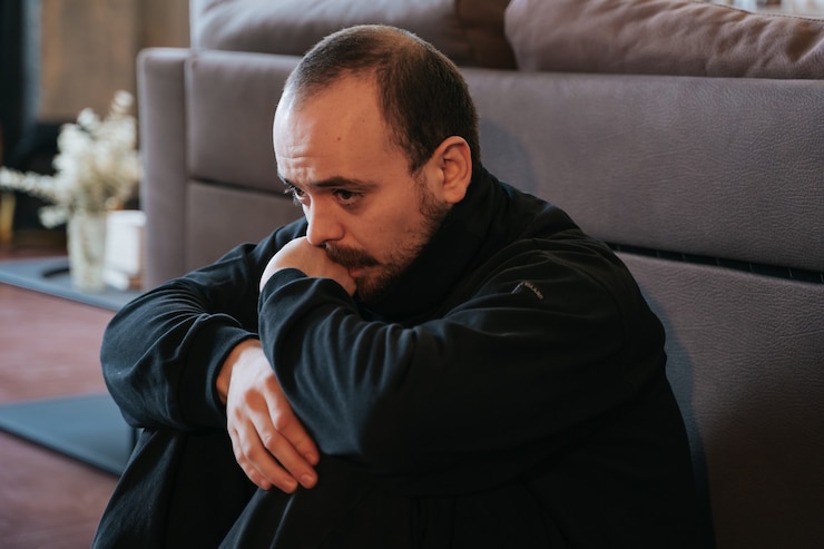 Foto giovane in depressione, preoccupato e triste, barbuto. seduto da solo