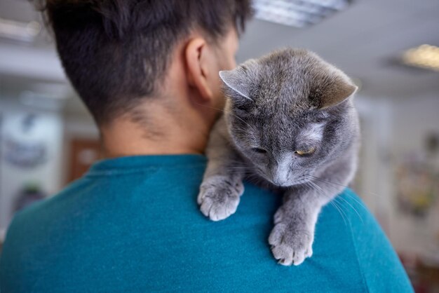 Giovane in maglietta che tiene un gatto