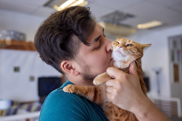 Giovane in maglietta che tiene un gatto