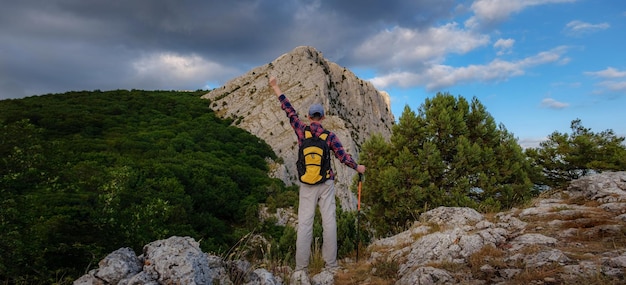 Giovane in piedi sulla cima della scogliera in montagna d'estate