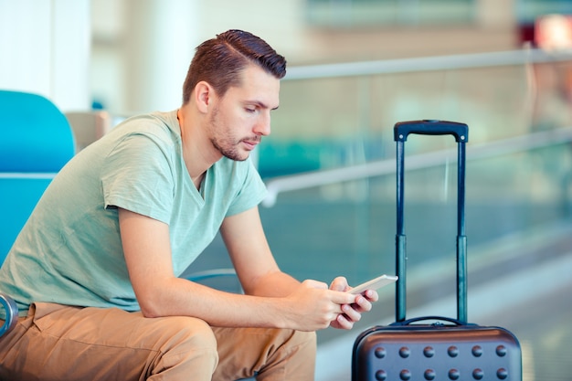 Giovane in un salotto dell'aeroporto in attesa di volo aereo.