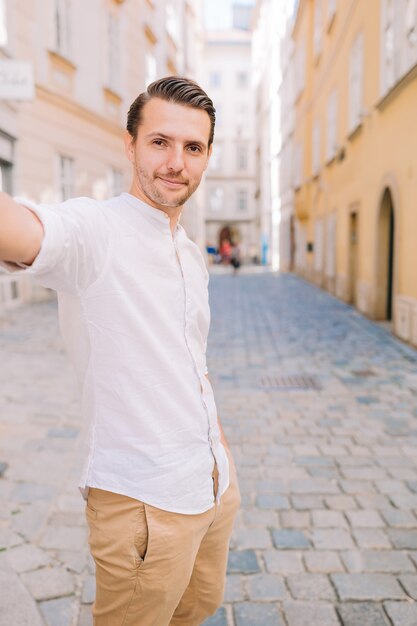 Giovane in una vecchia città europea prendendo selfie