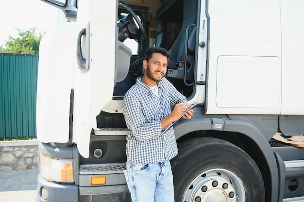 Giovane indiano in piedi vicino al suo camion Il concetto di trasporto merci