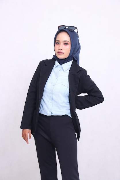 giovane indonesiana di ufficio in camicia blu hijab in piedi alla telecamera elegantemente dritto braccia verso il basso