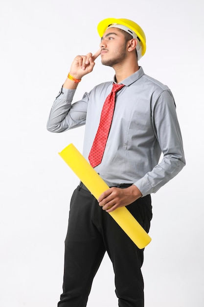 Giovane ingegnere indiano che indossa un elmetto di colore giallo e dà un gesto di successo.