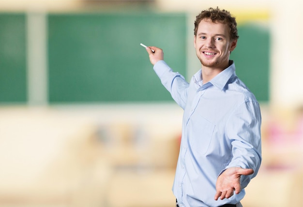 Giovane insegnante maschio in piedi in classe