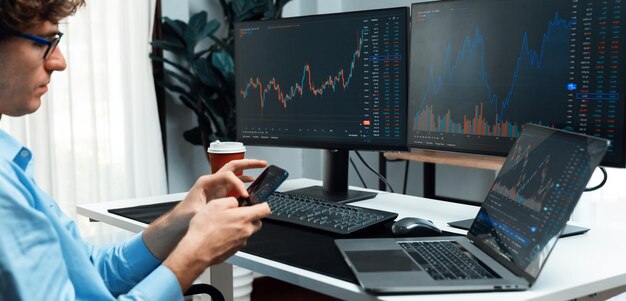 Giovane investitore che guarda sullo smartphone circondato dallo schermo del mercato attuale