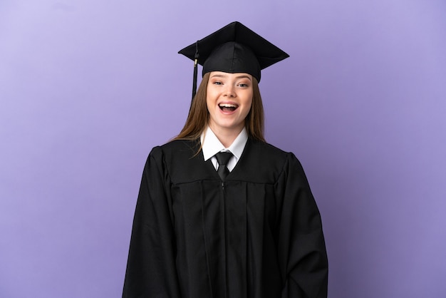 Giovane laureato su sfondo viola isolato con espressione facciale a sorpresa