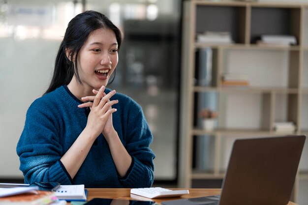 Giovane libera professionista o una studentessa seduta con il laptop sullo studio dal webinar online o da un corso a casa videochiamate e conversazioni