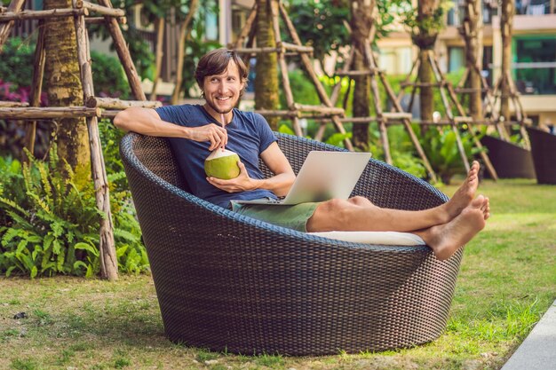 Giovane libero professionista che lavora in vacanza vicino alla piscina