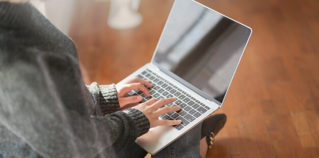 giovane libero professionista femmina digitando sul computer portatile mentre si lavora al suo progetto
