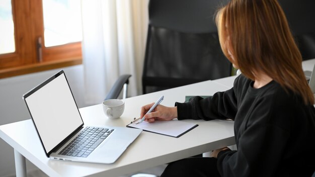 Giovane libero professionista femminile che lavora al suo incarico nel soggiorno. concetto di lavoro da casa.