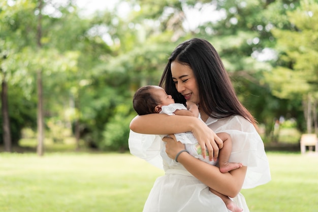 Giovane madre asiatica che tiene in braccio il suo neonato