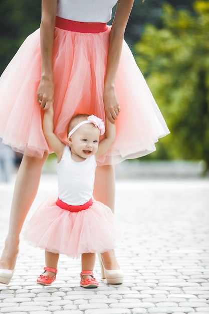 Giovane madre attraente con la sua piccola bambina all'aperto. Mamma e figlia.