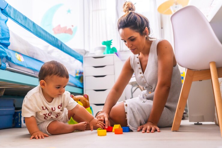 Foto giovane madre caucasica che gioca con lei nella stanza con i giocattoli