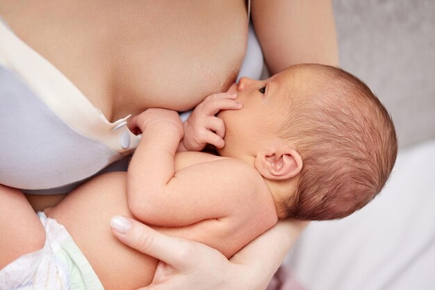 Giovane madre che allatta al seno il suo bambino appena nato a casa