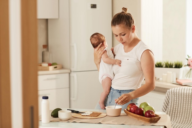 Giovane madre che cucina la colazione